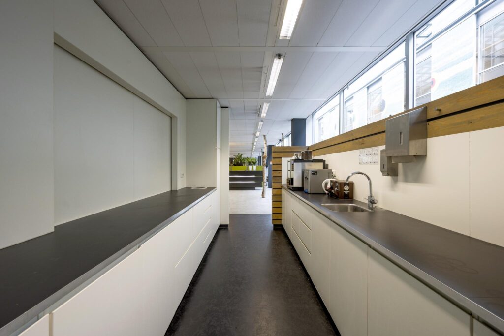 Modern office kitchenette at Jacob Bontiusplaats with coffee machines, sink, and ample counter space.